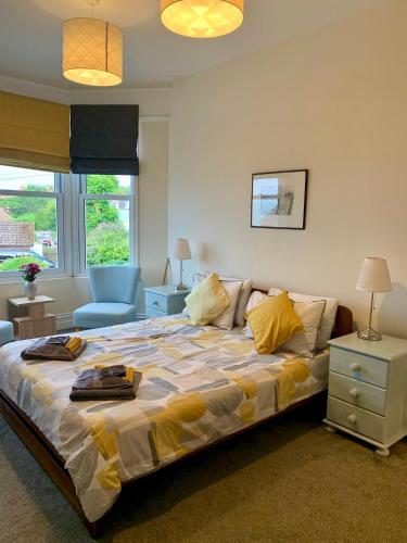 a bedroom with a large bed with yellow pillows at Caroline's House in Swanage