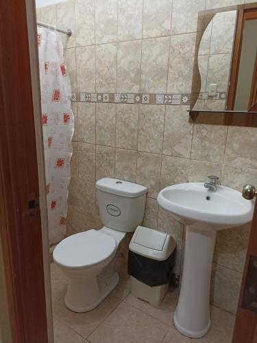 a bathroom with a toilet and a sink at Hospedaje Momentos in Tarapoto