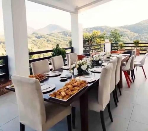 a dining room with a long table with white chairs at Top privacy Eco Villa of 2023 @ TEG hill Tirana in Tirana