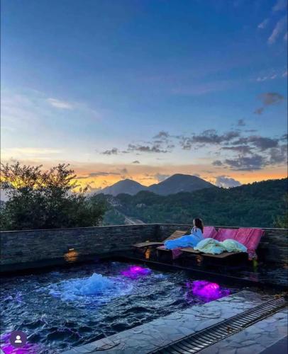 a woman laying on a bed next to a swimming pool at Top privacy Eco Villa of 2023 @ TEG hill Tirana in Tirana