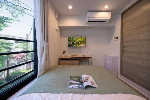 a bedroom with a bed and a window at ZAITO Waseda Terra Hotel in Tokyo