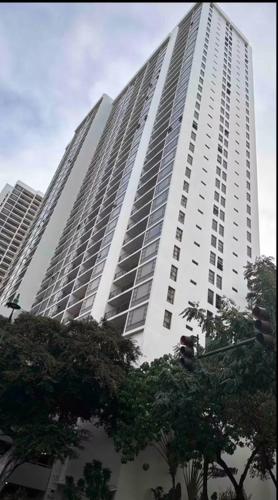 a tall white building with trees in front of it at Lovely APT AC, Free Parking, Ocean View in Honolulu