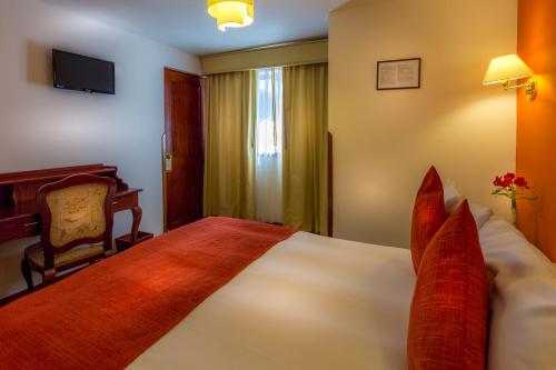 a hotel room with a large bed with red pillows at El Virrey Boutique in Cusco