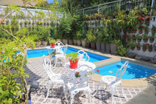 a patio with a table and chairs next to a pool at Boutique Hotel Premium Vendimia in Santa Cruz