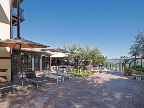 a patio with benches and umbrellas in a building at Marche Hilltop Villa with Pool in Tolentino