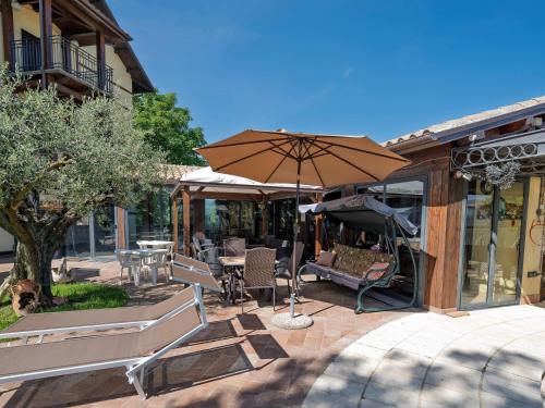 a patio with an umbrella and chairs and tables at Marche Hilltop Villa with Pool in Tolentino