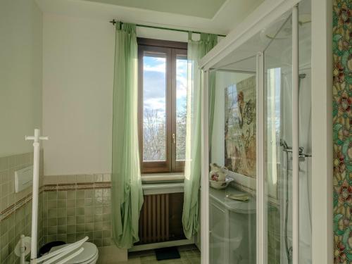 a bathroom with a shower and a toilet and a window at Marche Hilltop Villa with Pool in Tolentino