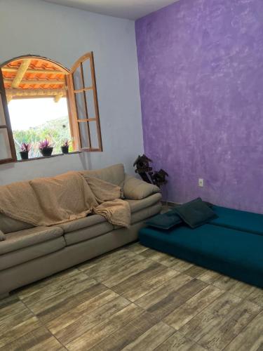 a living room with a couch and a window at Chácara Carvalho in Sabará