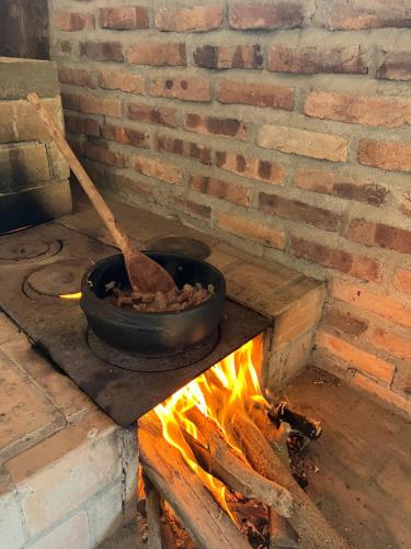 a pot over a fire in a brick oven at Chácara Carvalho in Sabará