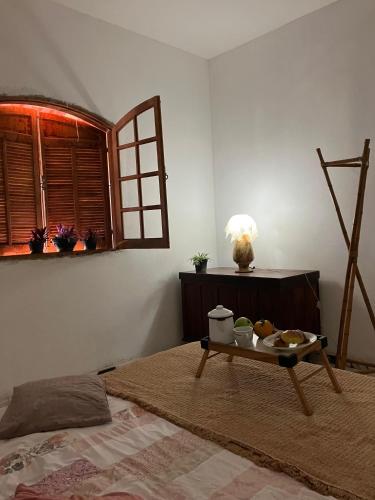 a room with a bed and a tray of food on a table at Chácara Carvalho in Sabará