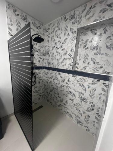 une cabine de douche dans une salle de bains avec du papier peint à motifs floraux dans l'établissement Tanki flip Property 2, à Noord