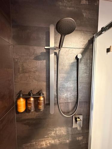 a shower with a shower head in a bathroom at Beaks and Feathers Boutique Accommodation on Stewart Island in Stewart Island