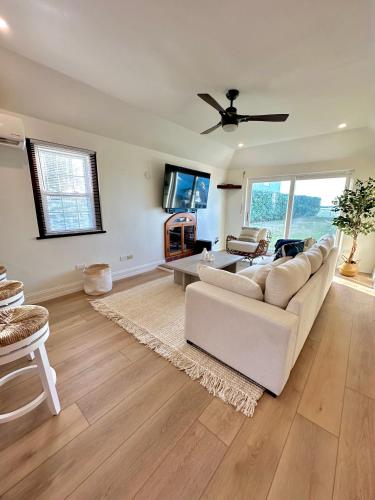 a living room with a white couch and a ceiling fan at Blue Water in Southampton