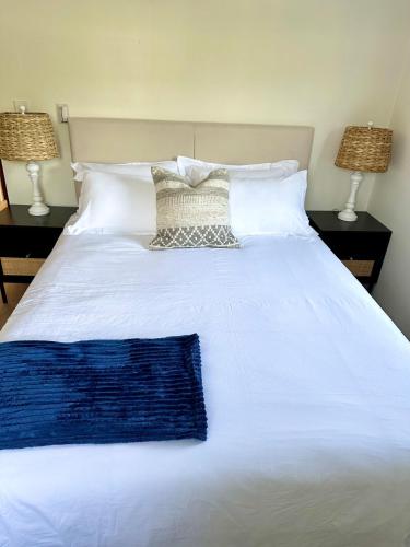 a white bed with a blue blanket and two lamps at Blue Water in Southampton