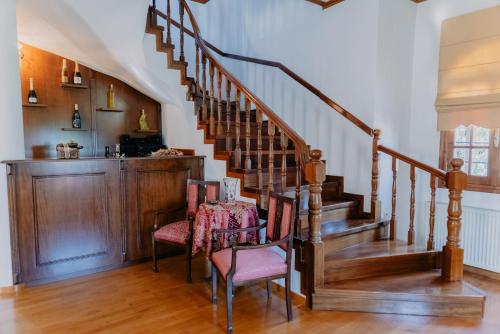 a staircase in a home with two chairs and a table at Aria Archontiko Pelion in Katochori