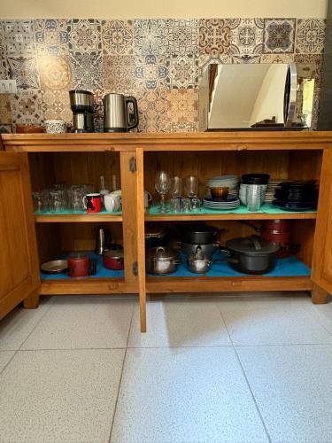 a wooden shelf with pots and pans and a microwave at Casa dos Sonhos in São Sebastião