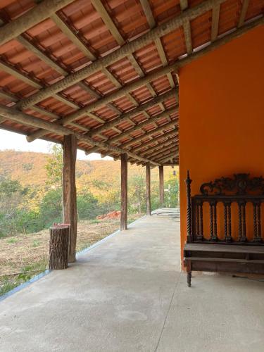 a porch with a bed and a wooden roof at Chácara Carvalho in Sabará