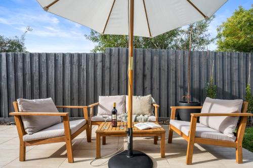 a patio with two chairs and a table with an umbrella at SAUNA & ICE BATH! - Your Health Retreat Escape in Capel Sound
