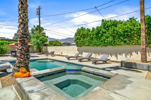 a swimming pool with two chairs and a palm tree at Palm Springs Home with a Resort Style Backyard -Joy pool hot tub views in Palm Springs