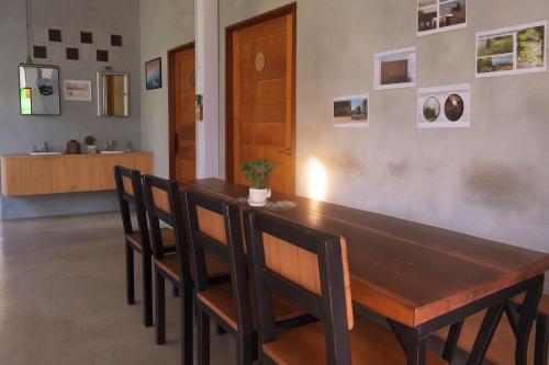 a dining room with a wooden table and chairs at Koh Tao Silver Na’s Hostel in Koh Tao