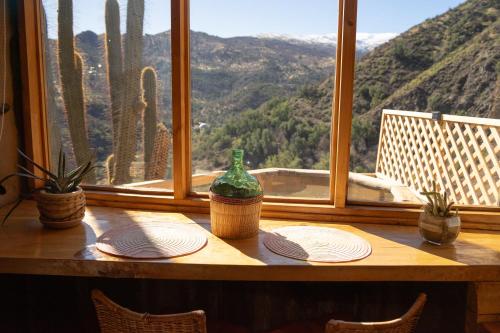 a table with plates and a vase on top of a window at Origen del Maipo Lodge in San José de Maipo
