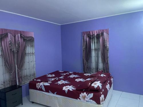 a bedroom with a bed with purple walls and curtains at DeDe's Place in Babonneau
