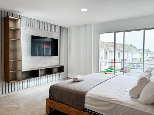 a bedroom with a large bed with a flat screen tv at Casa de Lujo, Parking, Piscina, Gym, Juegos in Guayaquil