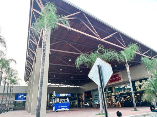 two palm trees in front of a shopping center at Casa de Lujo, Parking, Piscina, Gym, Juegos in Guayaquil