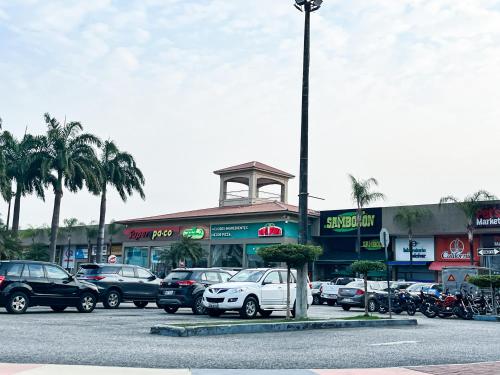 a parking lot with cars parked in front of a store at Casa de Lujo, Parking, Piscina, Gym, Juegos in Guayaquil