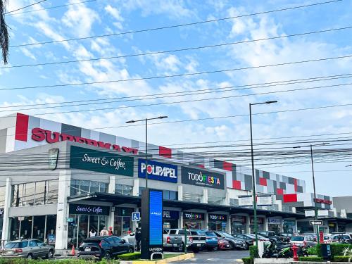 a store with cars parked in a parking lot at Casa de Lujo, Parking, Piscina, Gym, Juegos in Guayaquil