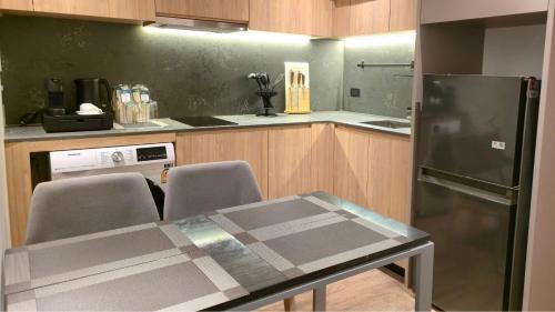 a kitchen with a table and a refrigerator at La Green Hotel and Residence in Bang Tao Beach