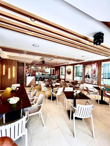 Un restaurante con mesas y sillas y un bar. en Hôtel Réstinga Martil, en Martil