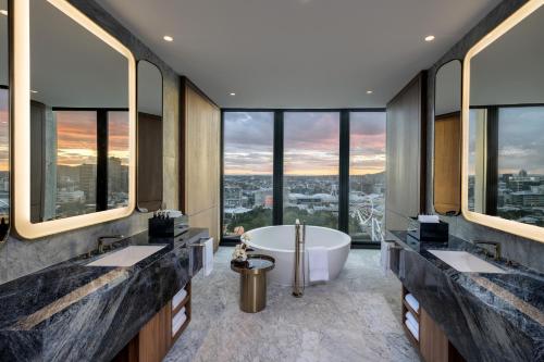 a bathroom with two sinks and a tub with a view at The Star Grand Brisbane in Brisbane