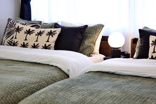 a bedroom with two beds with pillows at cuculu MAEJIMA 4F in Tomari