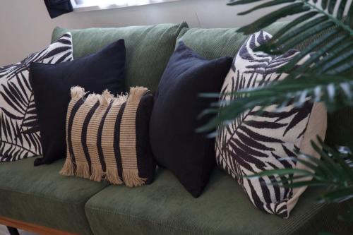 a green couch with several pillows on it at cuculu MAEJIMA 4F in Tomari