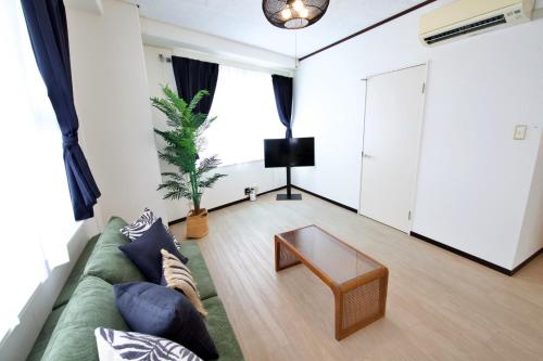 a living room with a green couch and a coffee table at cuculu MAEJIMA 4F in Tomari