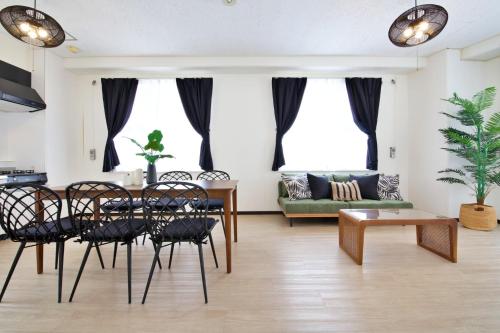 a living room with a table and chairs and a couch at cuculu MAEJIMA 4F in Tomari
