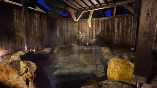 a pool of water with rocks in a building at HANZ OUTDOOR RESORT -formerly GLAMPING VILLA HANZ KAWAGUCHIKO in Fujikawaguchiko