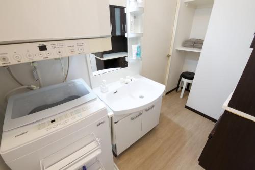 a small white kitchen with a sink and a dishwasher at cuculu MAEJIMA 4F in Tomari