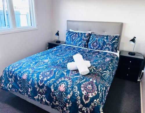 a bed with a teddy bear sitting on it at Merivale Court Family Suit in Christchurch