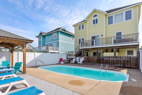 Un patio con piscina y una casa. en 6065 - Making Memories, en Nags Head