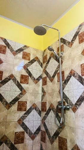 a shower in a bathroom with a tiled floor at Fare Tamaruorai in Tubuai