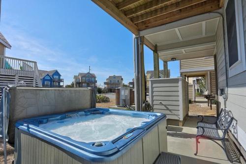 a large hot tub on a patio with a chair at 6156 - Family Tides in Nags Head