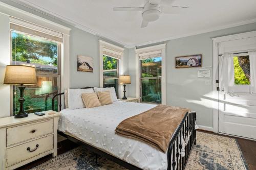 Un dormitorio con una cama y dos ventanas. en Peach Haus - Hot Tub & Fire Pit, en Fredericksburg