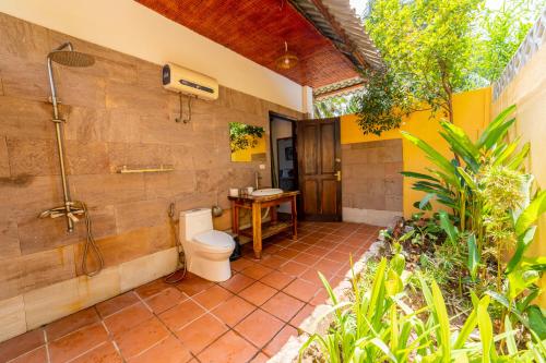 une salle de bain avec toilettes et douche dans l'établissement Dugong Resort Phu Quoc, à Duong Dong