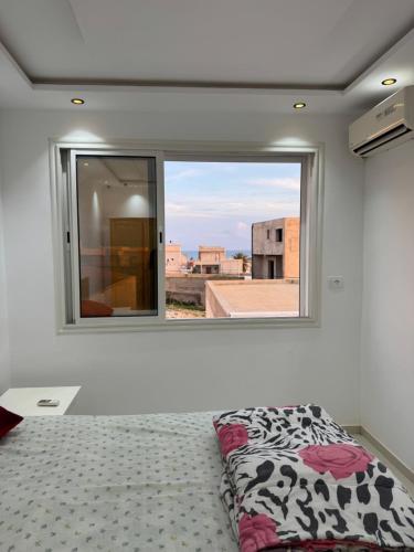 a bedroom with a bed and a large window at Small Home In salakata in Salakta