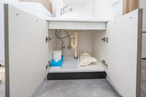 a bathroom with a sink under a counter at ZAITO Waseda Terra Hotel in Tokyo