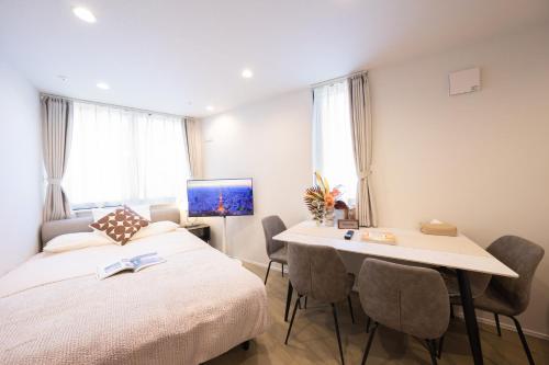 a bedroom with a bed and a table and chairs at ZAITO Waseda Terra Hotel in Tokyo