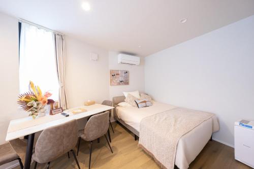 a bedroom with a bed and a desk and a bed and a table at ZAITO Waseda Terra Hotel in Tokyo