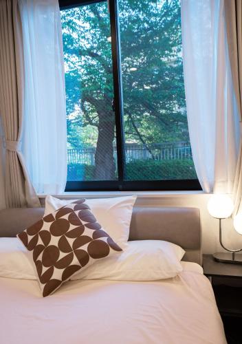 a bedroom with a large window and a bed at ZAITO Waseda Terra Hotel in Tokyo